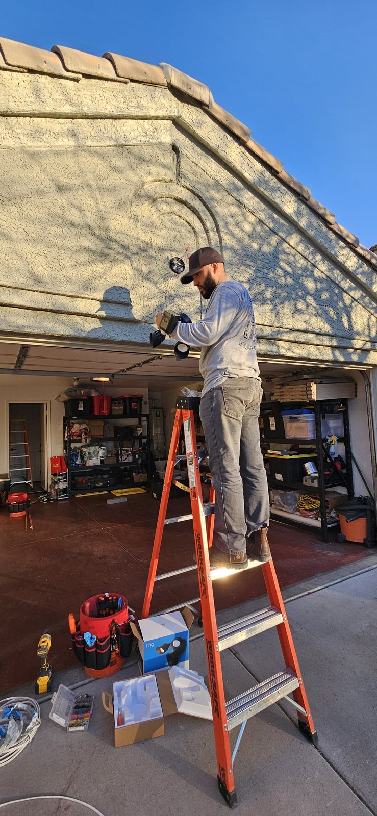Outdoor security light installation above a residential garage